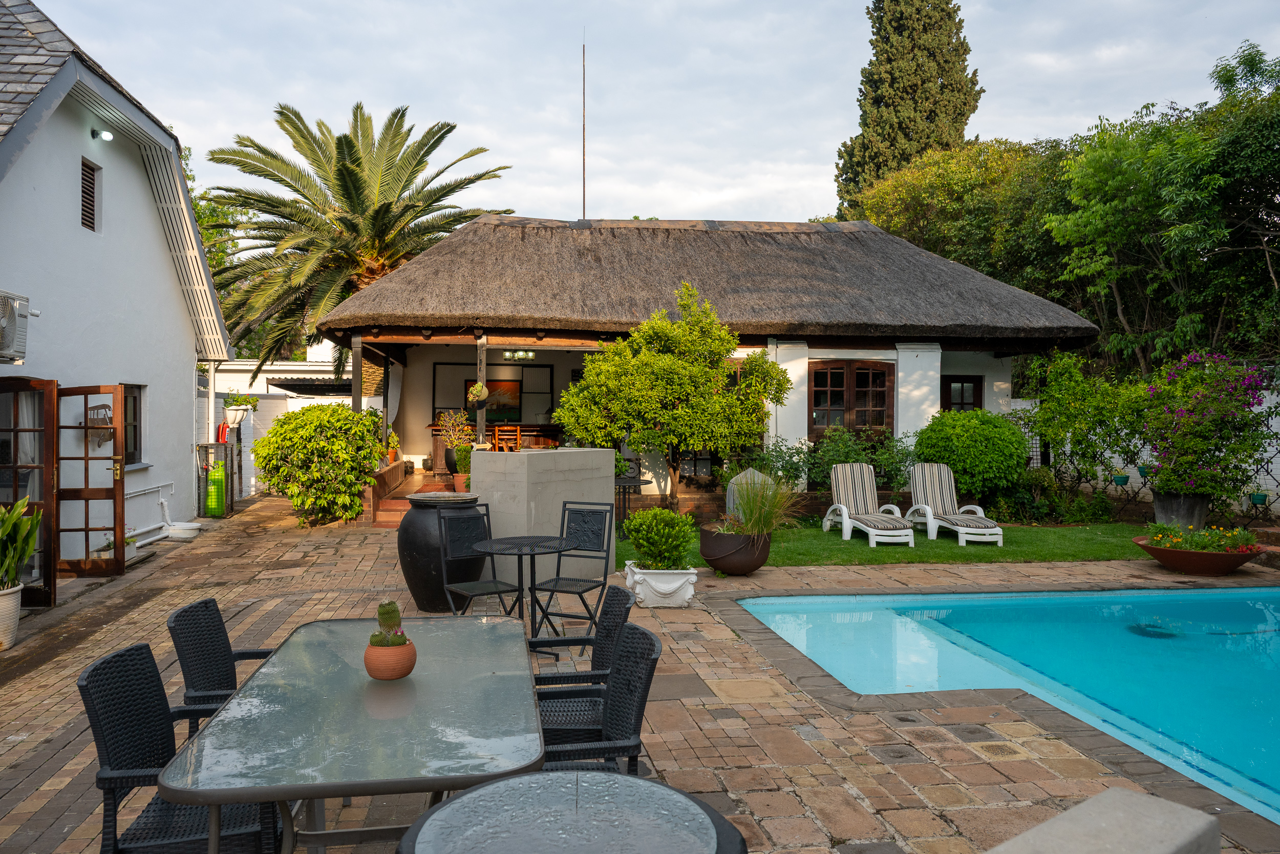 Outdoor seating beside the pool at dusk at 91Waverley Guesthouse, Bloemfontein