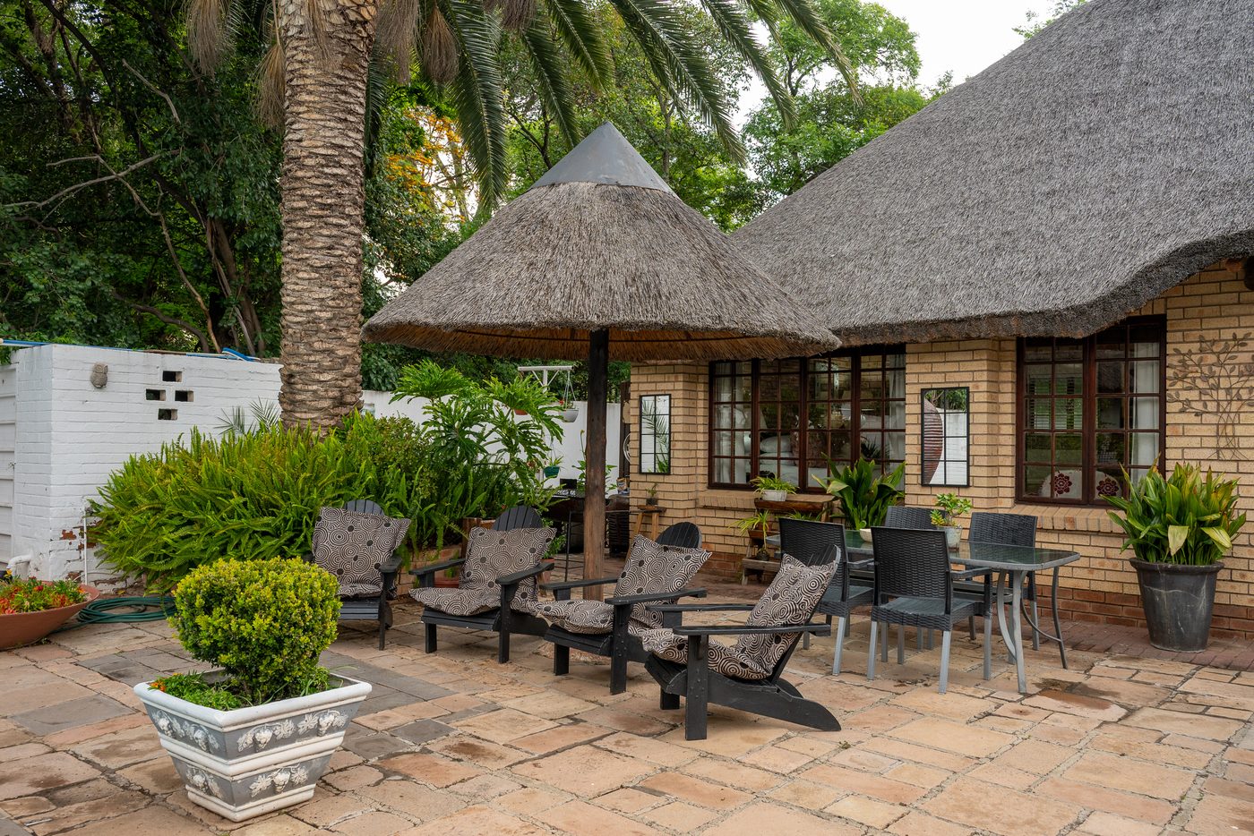 Garden seating and thatched cottage exterior at 91Waverley Guesthouse, Bloemfontein
