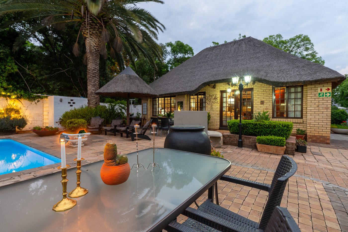 Outdoor seating beside the pool at dusk at 91Waverley Guesthouse, Bloemfontein